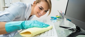 woman cleaning desk in office
