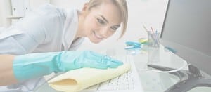 woman cleaning keyboard in office